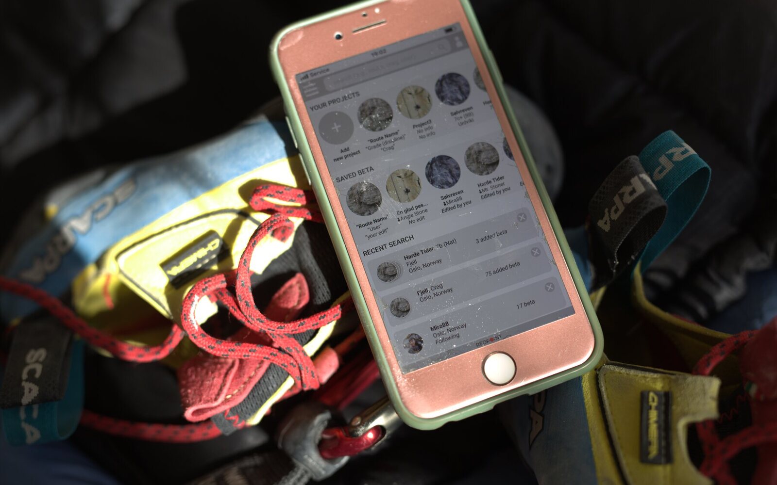 The Redpoint prototype on a phone next to climbing gear