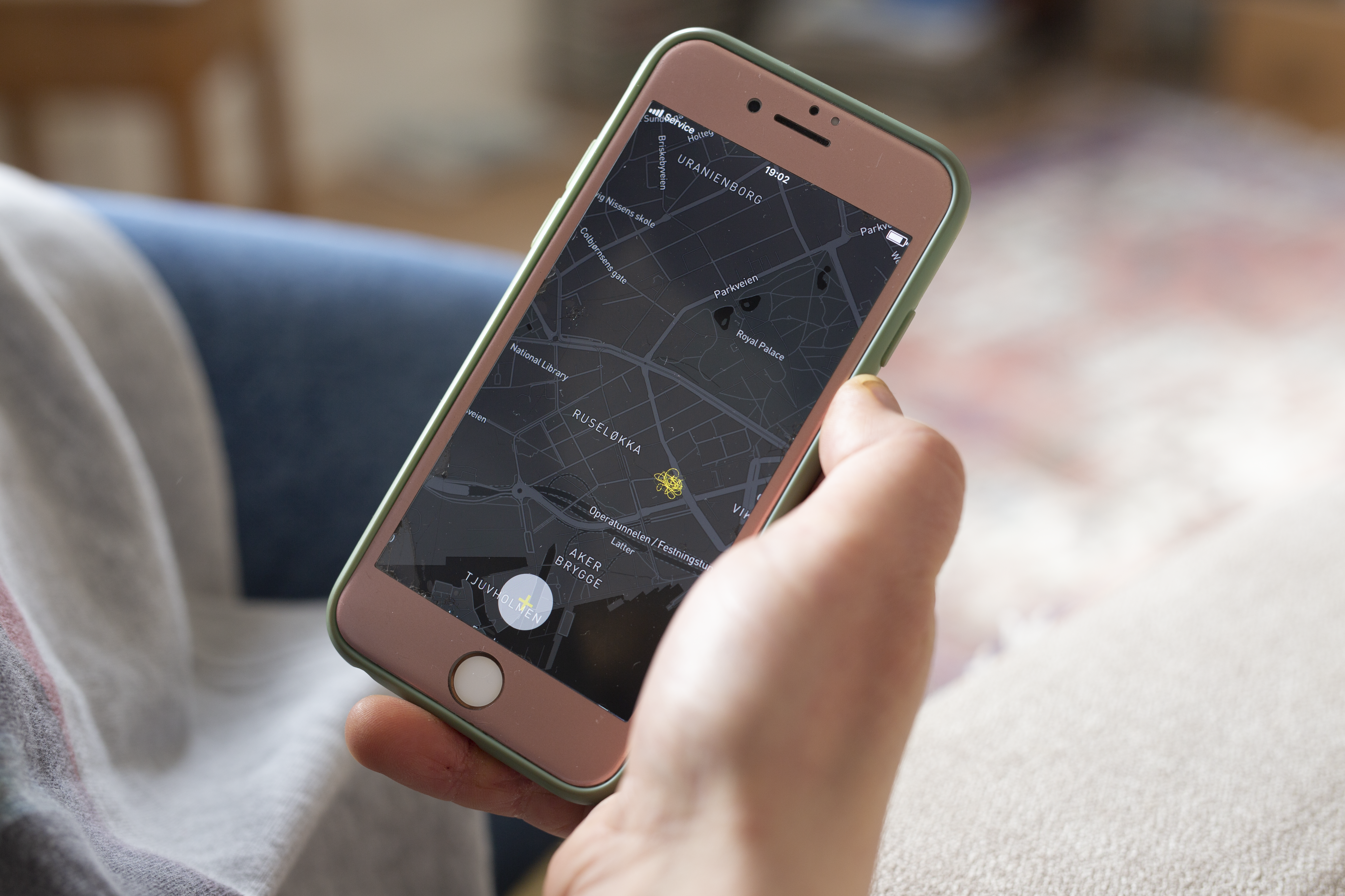 A hand holding a phone with the Sverm app